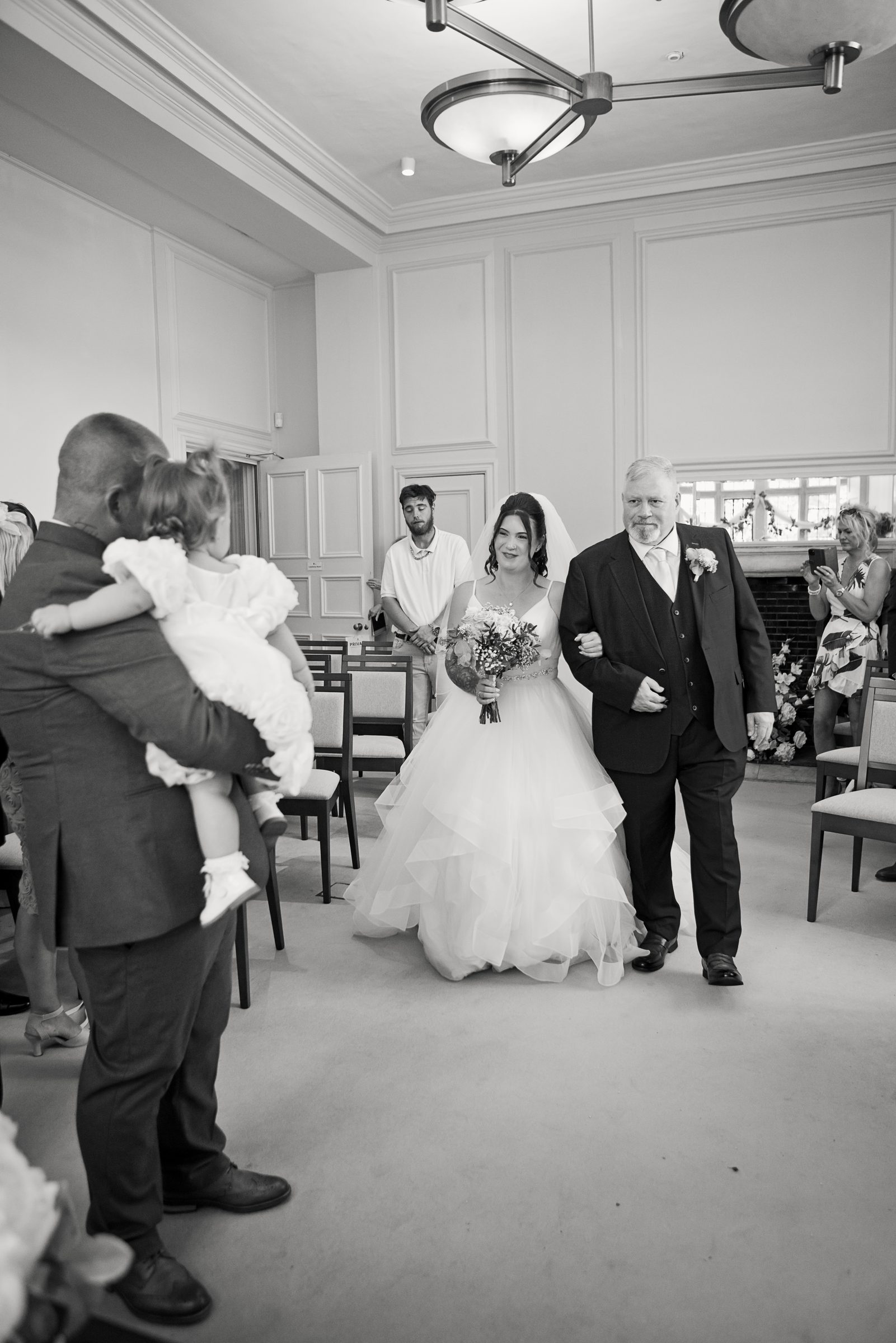 The bride walking the aisle, black and white